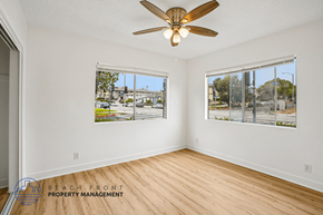 San Pedro apartment for rent - A room with a ceiling fan and two windows showing an outdoor view.