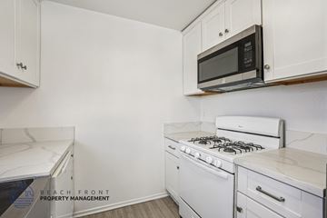 San Pedro apartment for rent - A white kitchen with a black microwave above the stove.