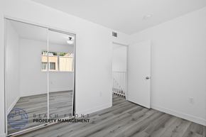 Van Nuys apartment for rent - a white walled room with a mirrored door and a staircase