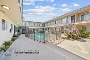 Gardena apartment for rent - A pool area of a building with a sign that says "Beach Front Property Management".