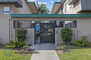 Downey apartment for rent - A gated entrance to a building with a sign that says "Property Management".