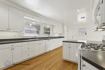 Long Beach apartment for rent - A modern kitchen with white cabinets and a black countertop.