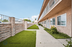 Downey apartment for rent - A long concrete walkway leads between two rows of houses.