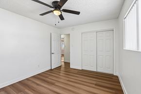 San Pedro apartment for rent - A room with a ceiling fan and wooden floors.