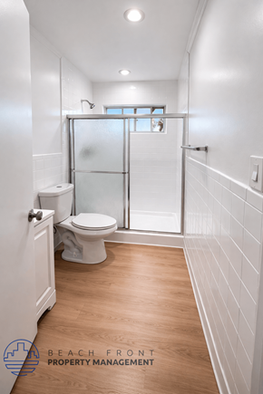 Long Beach apartment for rent - A white bathroom with a toilet, sink, and walk-in shower.