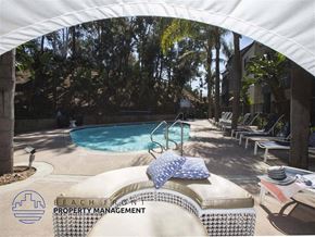 San Pedro apartment for rent - A pool area with a white canopy and a pool chair with a blue and white pillow on it.