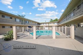 Inglewood apartment for rent - a swimming pool is behind a fence in an apartment building