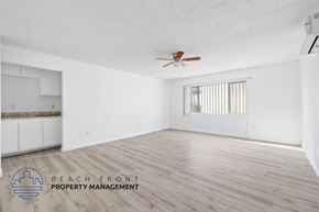San Pedro apartment for rent - A spacious room with a ceiling fan and wooden flooring.