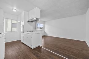 Huntington Park apartment for rent - A white kitchen with wood flooring and a window.