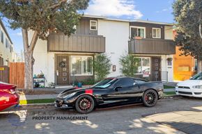 Long Beach apartment for rent - A black sports car is parked in front of a two-story building.