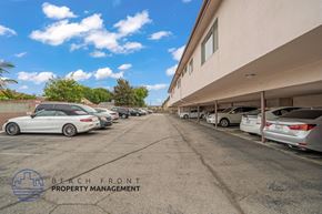 Hawthorne apartment for rent - A parking lot with cars and a building in the background.