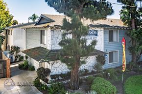 Torrance apartment for rent - A house with a sign that says "Renting" is surrounded by trees and bushes.
