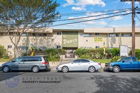 Inglewood apartment for rent - a parking lot in front of a building with cars parked in front
