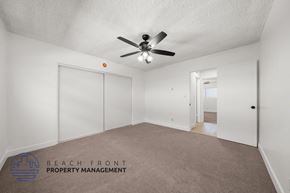 Hawthorne apartment for rent - A spacious room with a ceiling fan and carpeted floor.