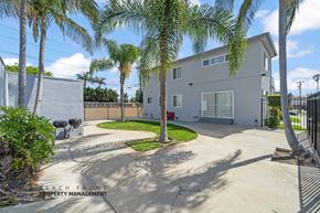 Gardena apartment for rent - A house with a driveway and palm trees in front.