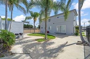Gardena apartment for rent - A house with a driveway and palm trees in front.