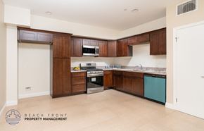 Harbor City apartment for rent - A kitchen with wooden cabinets and a white door.