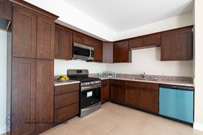 Harbor City apartment for rent - A kitchen with brown cabinets and a blue dishwasher.