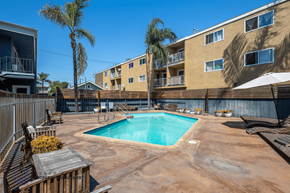 Long Beach apartment for rent - A pool surrounded by a patio and apartment buildings.