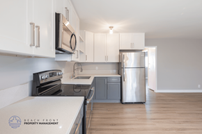 Long Beach apartment for rent - A kitchen with white cabinets and a stainless steel refrigerator.