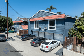 Long Beach apartment for rent - A blue house with a red roof and a sign that says Beach Front Property Management.