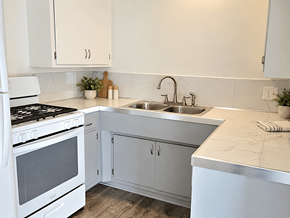 Redondo Beach apartment for rent - A white kitchen with a stove, sink, and cabinets.