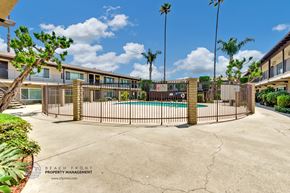 La Puente apartment for rent - A pool surrounded by a fence with palm trees in the background.