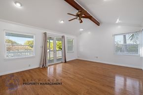 Lomita apartment for rent - A spacious room with wooden floors and a ceiling fan.