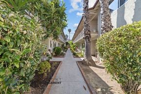 Inglewood apartment for rent - a sidewalk with palm trees and houses on either side of it