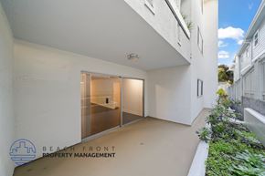 Redondo Beach apartment for rent - A modern building with a white exterior and a glass door entrance.
