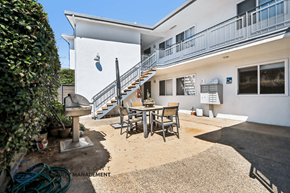 Long Beach apartment for rent - A white building with a balcony and a staircase leading to the second floor.