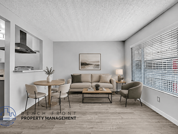 Long Beach apartment for rent - A living room with a dining table and chairs, a couch, a coffee table, and a painting on the wall.