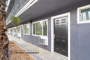 Whittier apartment for rent - A building with a black door and windows with shutters.