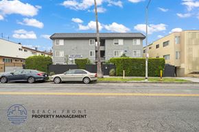 Los Angeles apartment for rent - A street view with cars parked and a building with the sign "BEACH FRONT PROPERTY MANAGEMENT".
