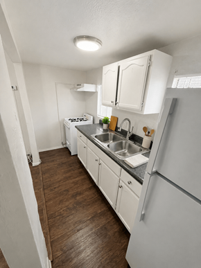 Signal Hill apartment for rent - A kitchen with white appliances and wooden floors.