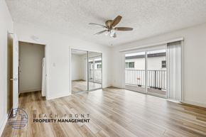 Newport Beach townhouse for rent - A spacious room with a ceiling fan and wooden flooring.