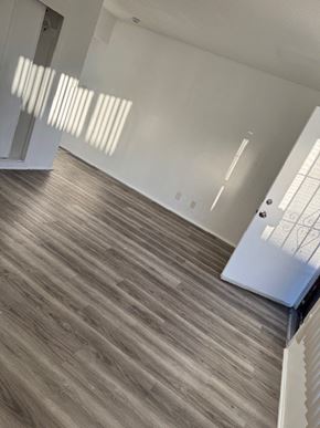Gardena apartment for rent - A room with a wooden floor and white walls.