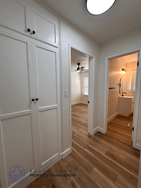 Santa Ana apartment for rent - A white wooden hallway with a round light on the ceiling.