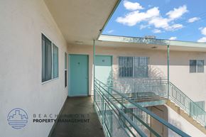 Wilmington apartment for rent - A balcony with a glass railing and a blue door.