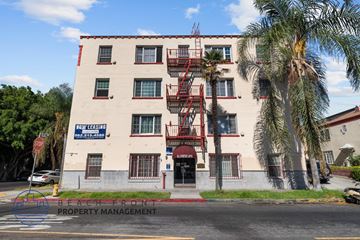 Los Angeles apartment for rent - A building with a sign that says "Now Leasing" is in front of some trees.
