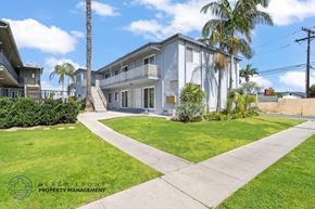 Gardena apartment for rent - A two-story house with a balcony and a palm tree in front.