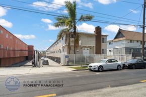 Inglewood apartment for rent - A street view with cars parked on the side and a building with the text "BEACH FRONT PROPERTY MANAGEMENT" on it.
