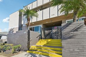 Santa Ana apartment for rent - A modern building with a yellow staircase leading to the entrance.
