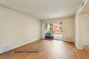 Santa Ana apartment for rent - A room with wooden floors and a window overlooking a building.