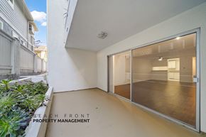 Redondo Beach apartment for rent - A balcony with a glass door leading to a room with a white wall.