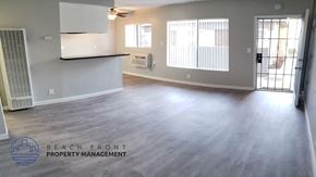 Downey apartment for rent - A spacious room with a ceiling fan and sliding glass doors leading to a balcony.