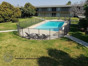 Buena Park apartment for rent - a backyard with a pool and a chain link fence around it