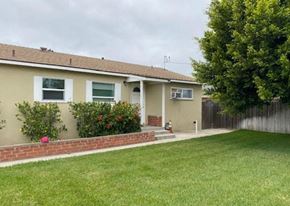 Santa Ana apartment for rent - a yellow house with a lawn and a fence