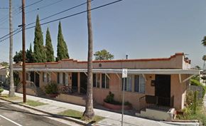 San Pedro apartment for rent - a pink building with a porch and a street
