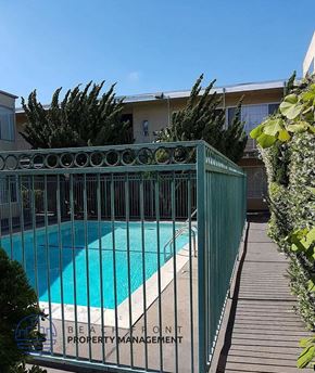 Lawndale apartment for rent - a swimming pool is behind a wrought iron fence